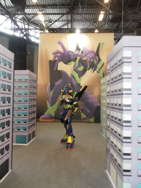 Un cosplayer nei panni dell'Eva-01 si aggira tra i palazzi di Neo Tokyo-3